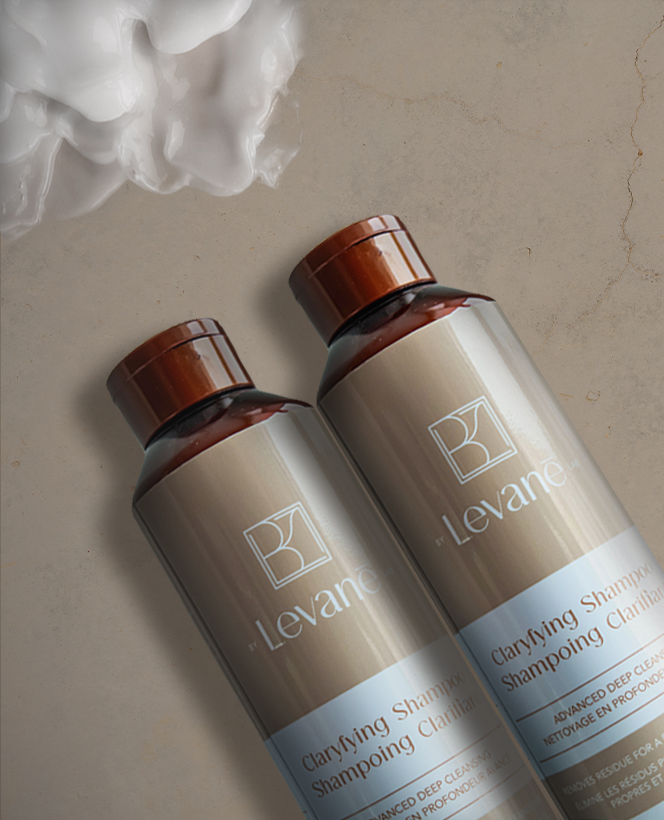 Two bottles of Levante clarifying shampoo on a textured surface with white foam.